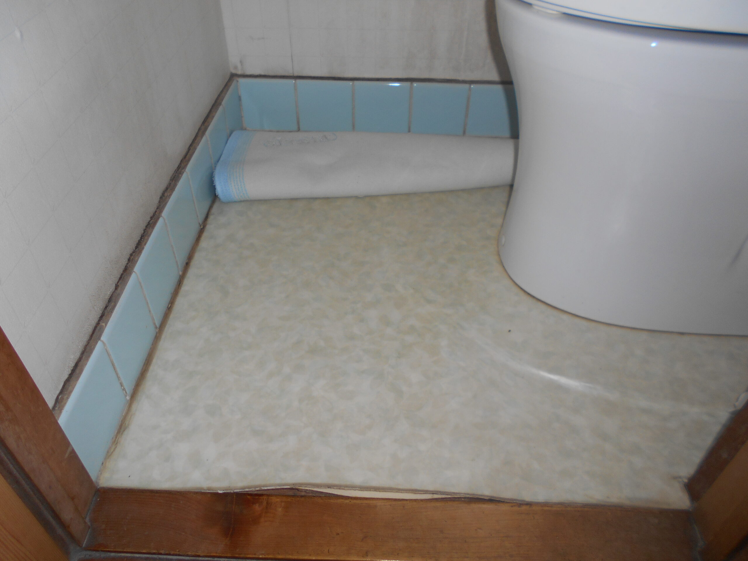 町田市トイレリフォーム施工前。床材が剥がれ、隙間ができている様子