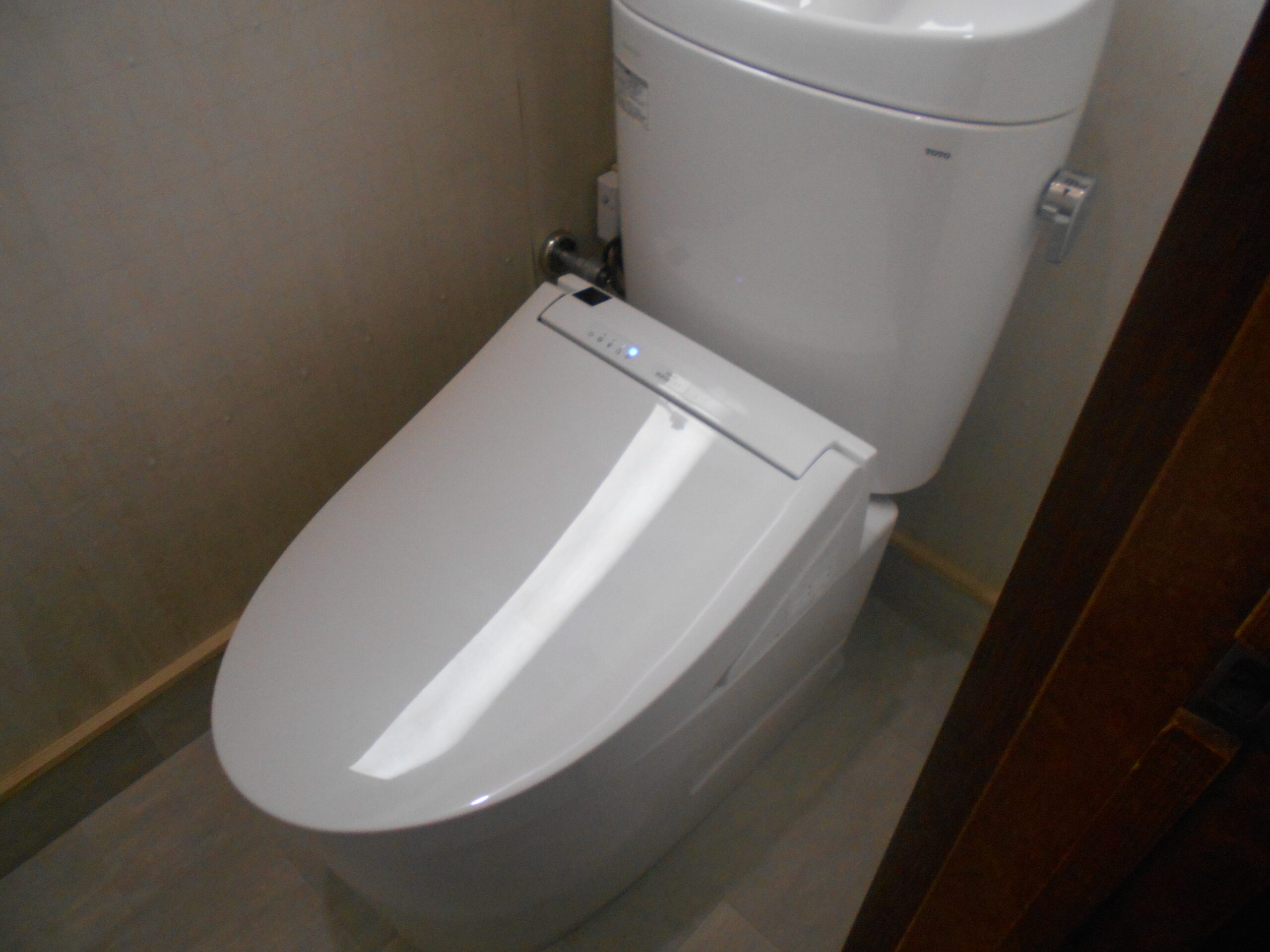 施工後。新しい便器と美しい木目調の床で明るくなったトイレ空間